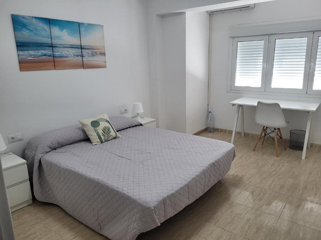 a bedroom with a bed and a desk and a table at apartamento san urbano in Almería