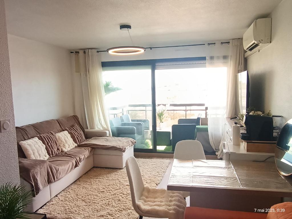 un salon avec un canapé et une table dans l'établissement Studio à Valras, à Valras-Plage