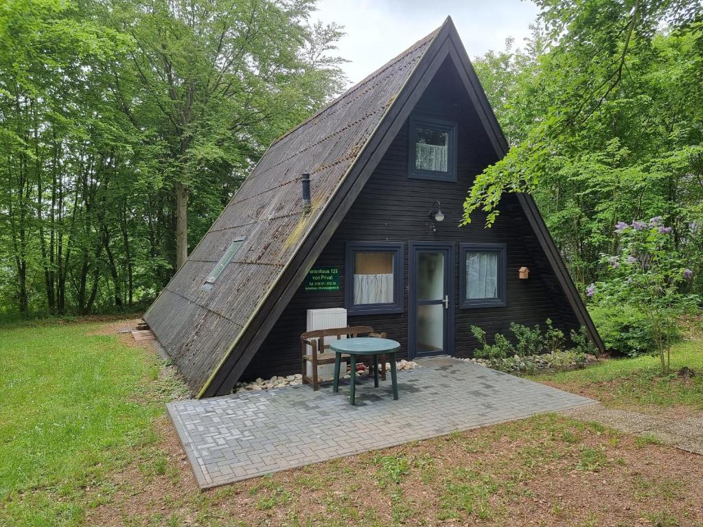 a black cabin with a thatched roof at Ferienhaus Marie 125 in Bad Arolsen