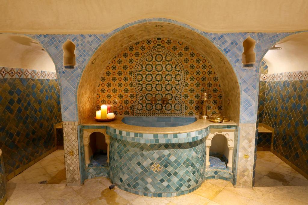 a bathroom with a tub with a candle in it at Riad Cherifa in Chefchaouene