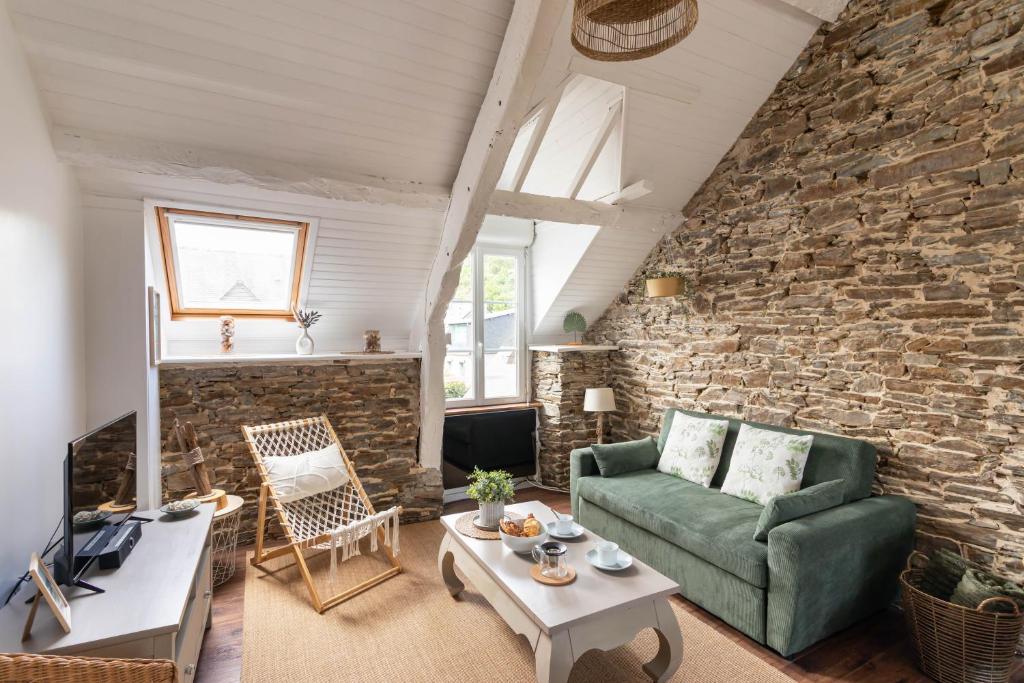 カンカルにあるRêve Emeraude - 100m de la Plageの緑のソファとレンガの壁が備わるリビングルーム