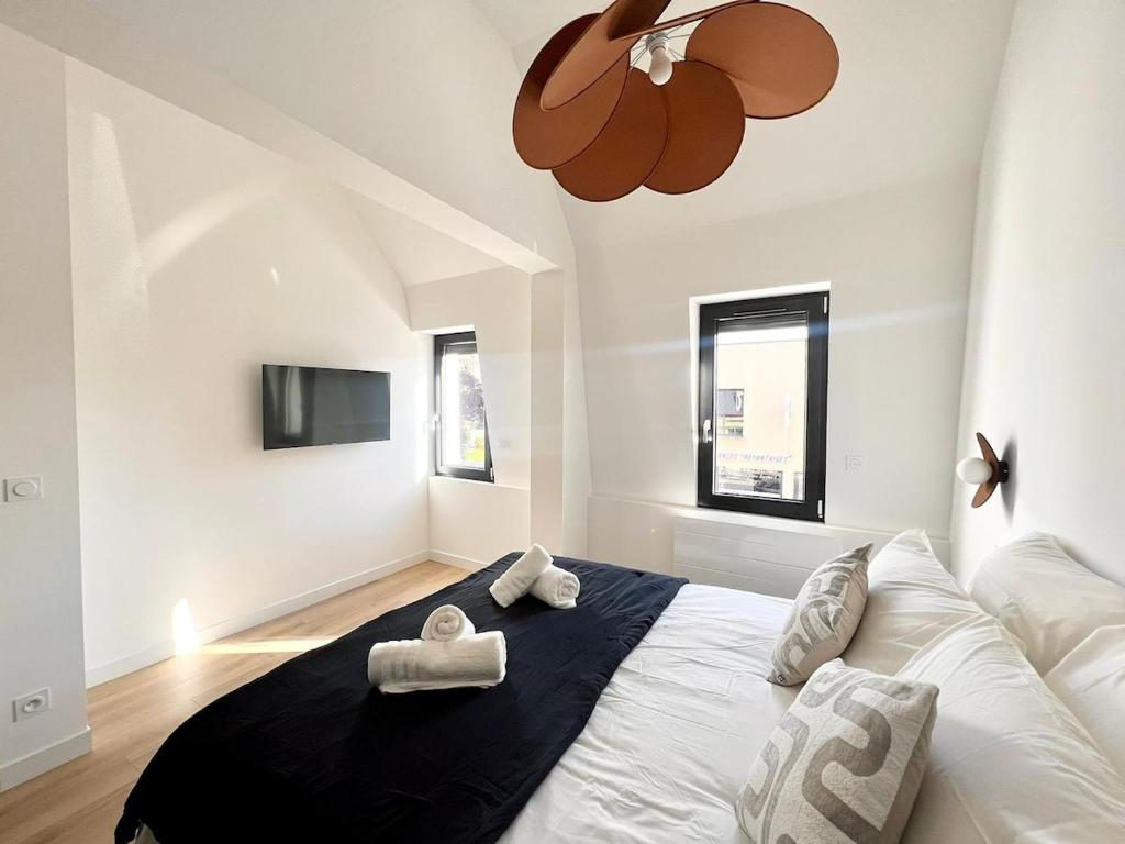a bedroom with a large bed with two towels on it at Appartement le Vintage, à deux pas du Port in Le Tréport