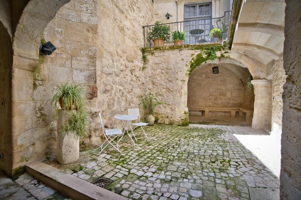 an alley with two chairs and a table in a building at La suite du Duché in Uzès