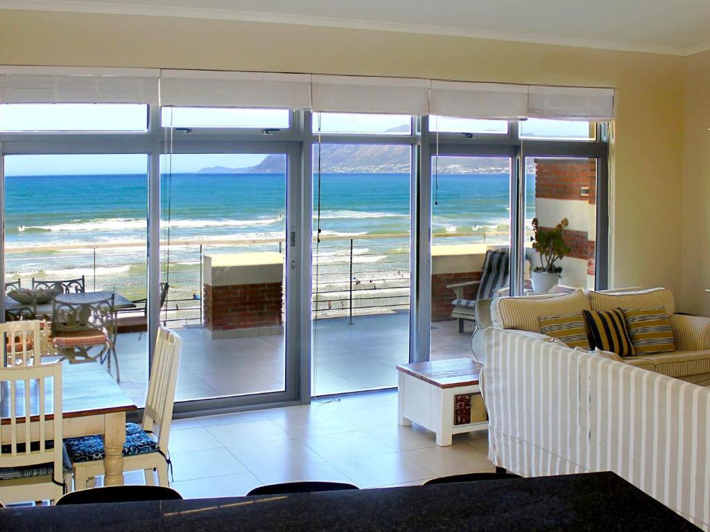 Una sala de estar con vista al mar. en Bluebird Empire Penthouse, en Muizenberg