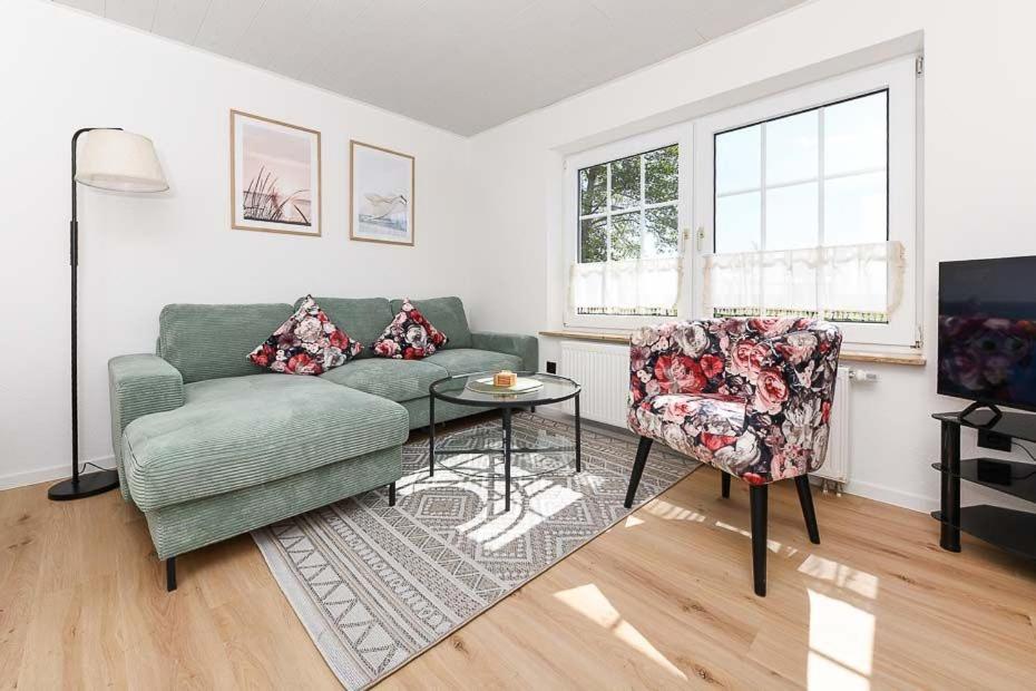 Una sala de estar con un sofá, una mesa y una silla. en Ferienwohnung Sternstunde, en Bensersiel