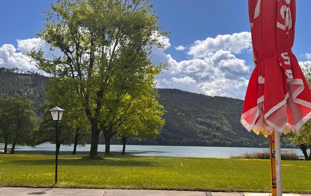 una bandiera su un palo con un lago sullo sfondo di Lakeside Inn a Spittal an der Drau