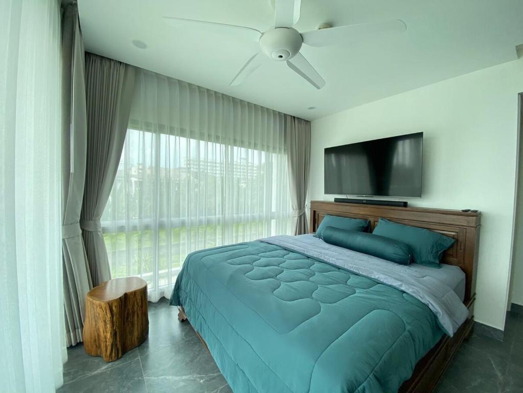 een slaapkamer met een groot bed en een flatscreen-tv bij The gallery condominium Ben in Jomtien Beach