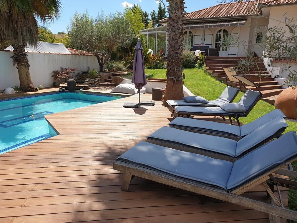 - une piscine avec des chaises longues à côté d'une maison dans l'établissement Moment de rêve guaranti, à Baillargues