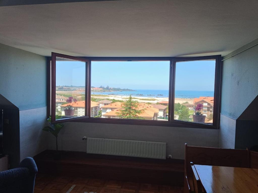 a room with a large window with a view of the ocean at Atico in Noja Helgueras in Noja