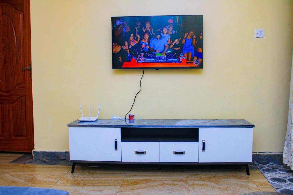 a tv on a wall with a white cabinet at Gardenview Homes -2 Bedroom Apartment along Nyeri-Nanyuki Road -Kingongo in Nyeri