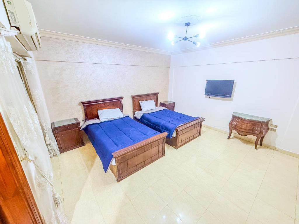 a bedroom with two beds and a tv in it at Big Flat in Dokki Twin Room Private Bathroom in Cairo