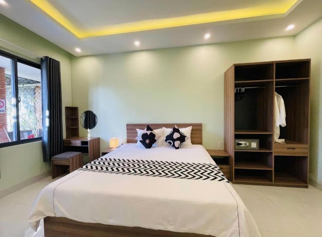 a bedroom with a large bed and a tv at Hy Viên boutique Garden & Swimming pool in Cồn Giả Viên