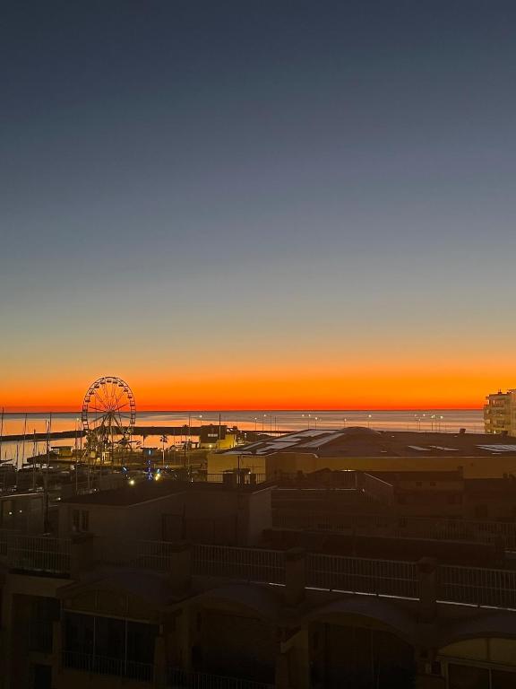 une vue d'une grande roue et d'une plage au coucher du soleil dans l'établissement Panoramic view, Quiet, Modern, Wi-Fi, Parking, à Canet