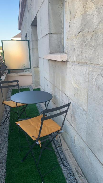 2 tables et chaises assises à côté d'un bâtiment dans l'établissement Appartement au cœur de Rouen, à Rouen