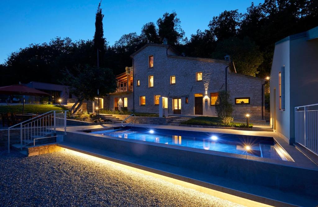 a house with a swimming pool in front of a house at Le Cune, Apt Belvedere - AC, Pool & Jacuzzi in Palazzo
