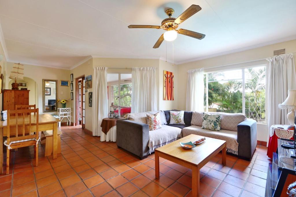 a living room with a couch and a table at Lily's Cottage in Durban