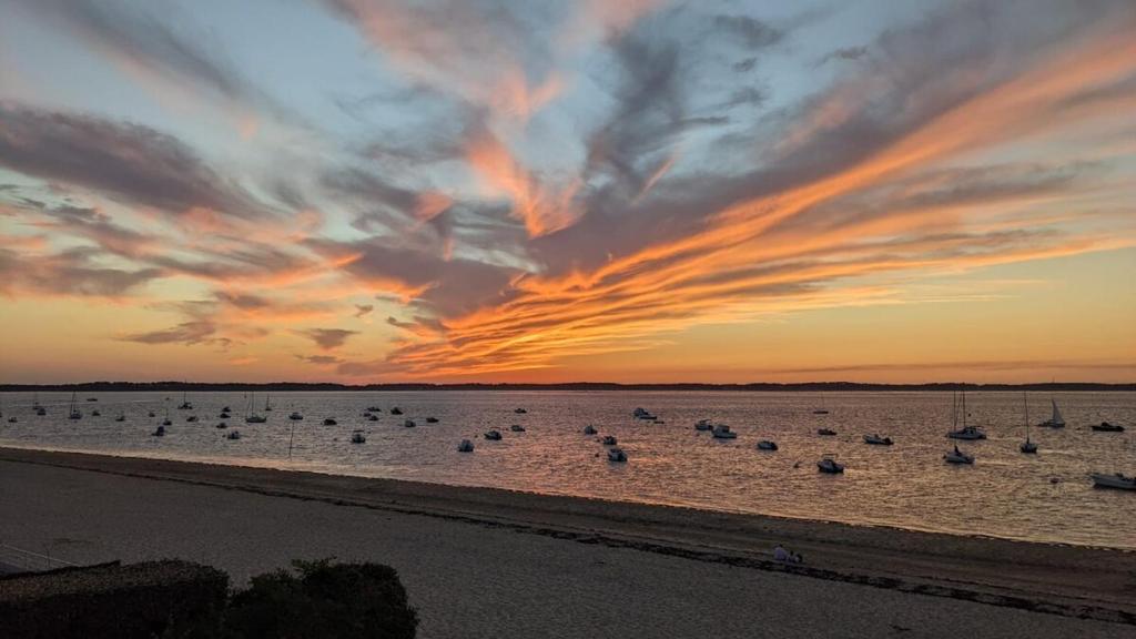 un groupe de bateaux dans l'eau au coucher du soleil dans l'établissement Grand T2 direct sur la plage Arcachon Pereire, à Arcachon