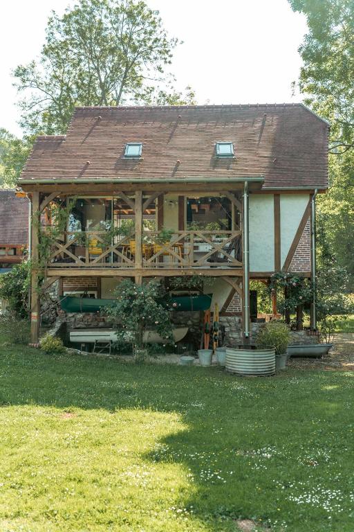 une grande maison en bois avec un toit dans l'établissement La Rivière 10 mn DisneylandParis, à Chalifert