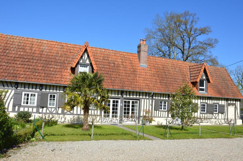 Ouville-la-RivièreにあるL'Orée des Prés - Gîte familial - 4 étoiles - 8 personnesの赤屋根の大白屋敷