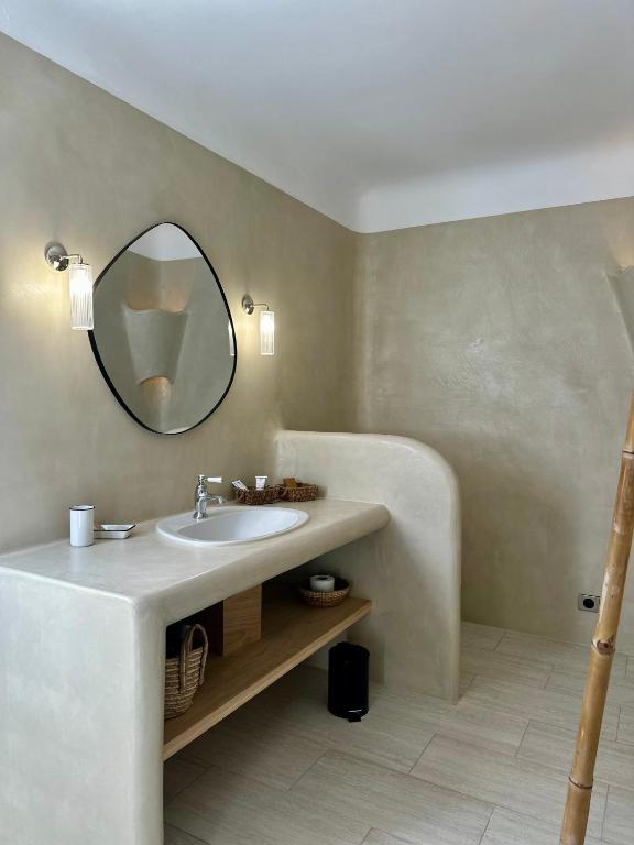 a bathroom with a sink and a mirror at Hôtel Palombaggia in Porto-Vecchio