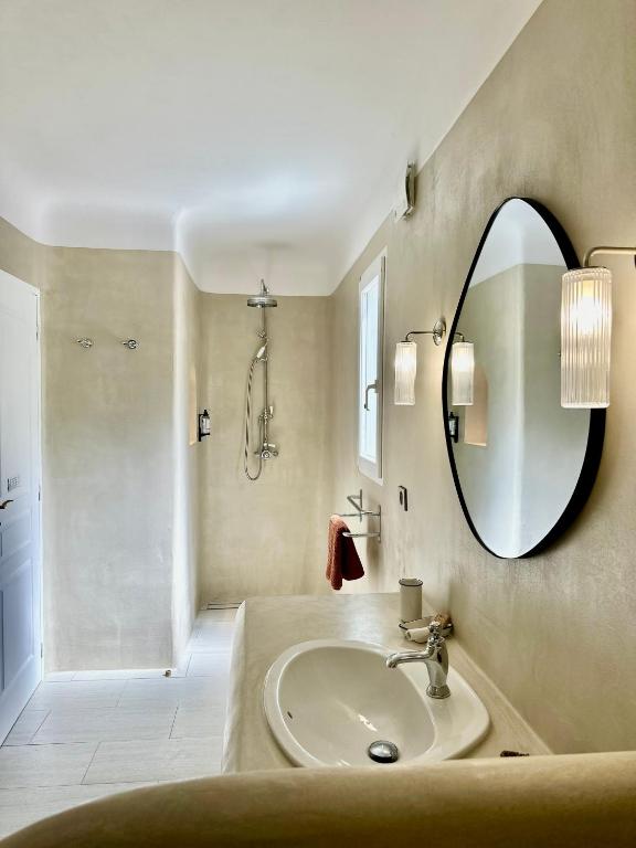 a bathroom with a sink and a mirror at Hôtel Palombaggia in Porto-Vecchio