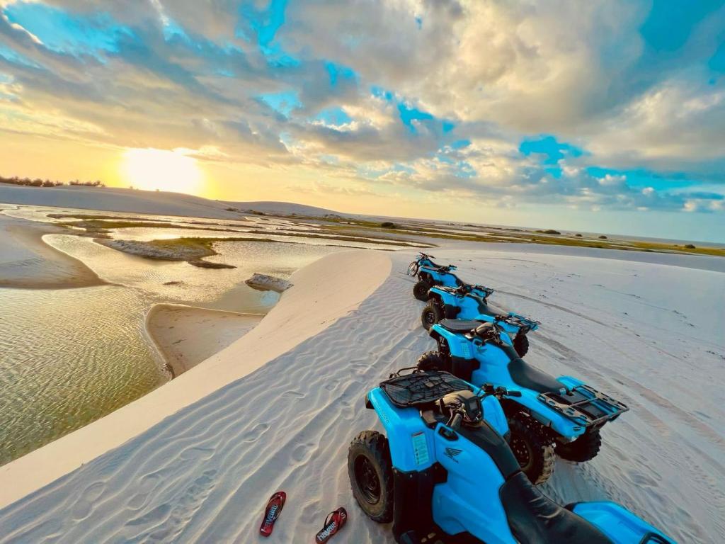 a line of motorcycles parked in the sand on the beach at Tô em Casa Hospedagem in Jijoca de Jericoacoara