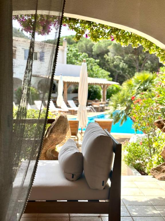 a hammock sitting on a patio with a pool at Hôtel Palombaggia in Porto-Vecchio