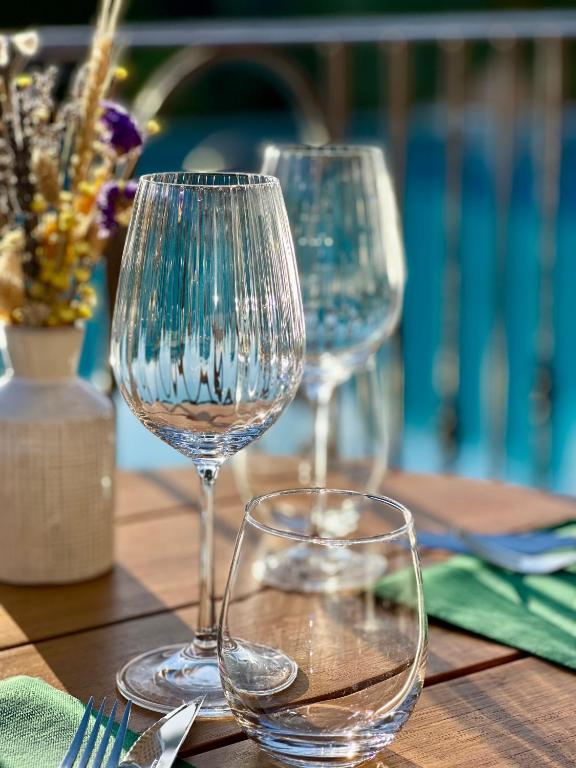 two empty wine glasses sitting on a wooden table at Hôtel Palombaggia in Porto-Vecchio