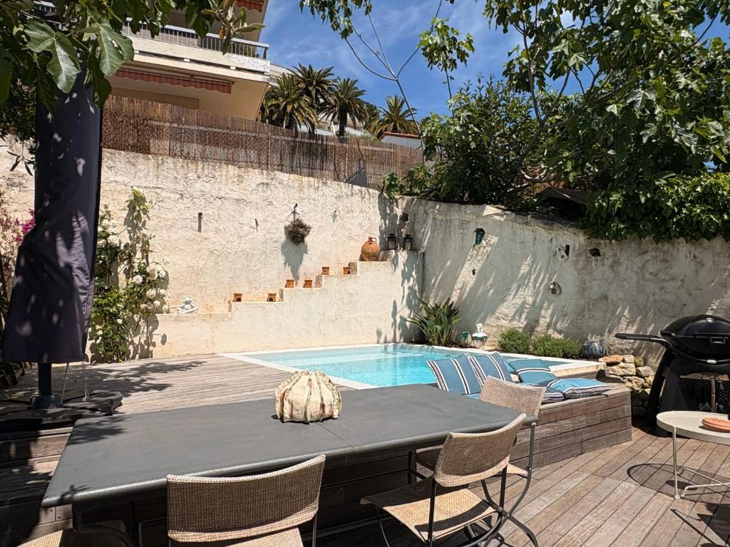 un patio avec une table et des chaises et une piscine dans l'établissement Charmante maison de village avec petite piscine privée, au Cannet