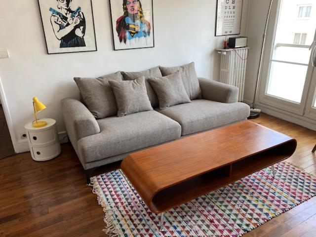 un salon avec un canapé et une table basse dans l'établissement Appartement design, à Boulogne-Billancourt