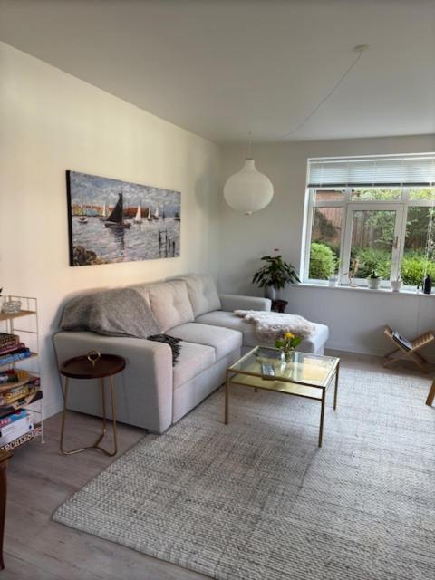 a living room with a couch and a table at Garden Apartment by the Sea in Sønderborg
