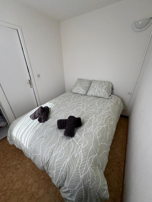 a bedroom with a bed with two teddy bears on it at Appartement 4 personnes à 50 m de la plage in Narbonne