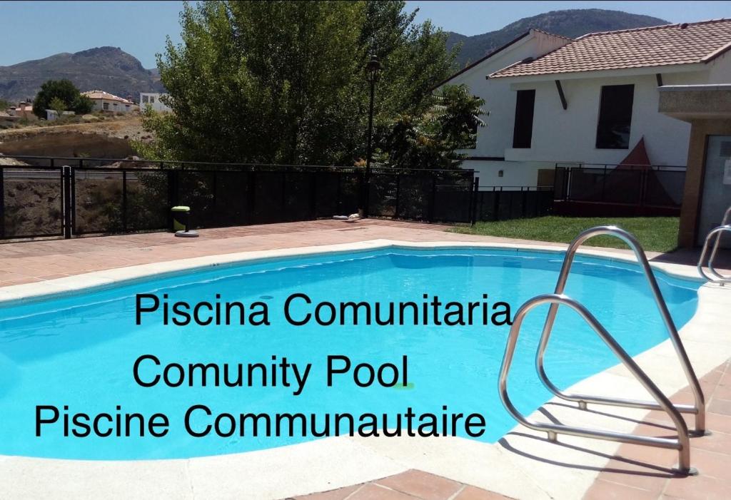 a swimming pool with a metal rail next to a house at La Casa del Pianista in Monachil