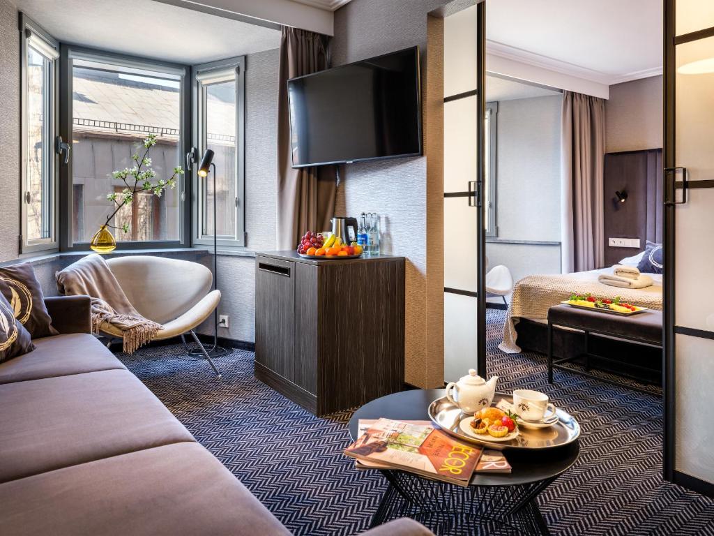 a hotel room with a bed and a living room at Hotel Logos Kraków in Krakow