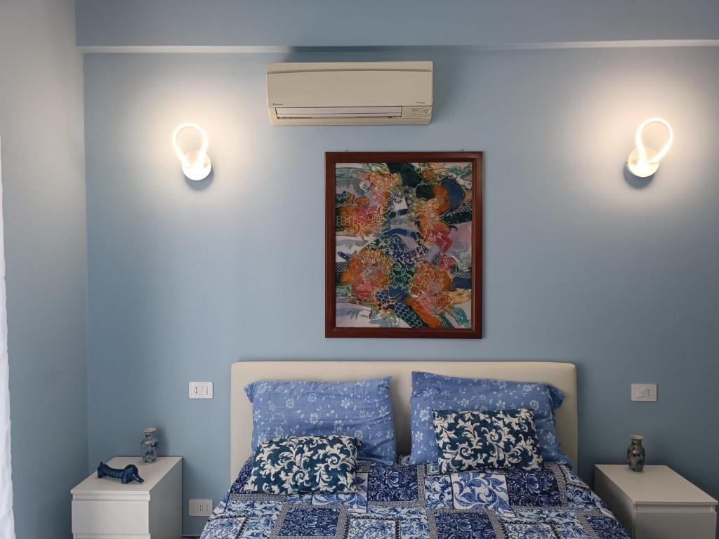 Un dormitorio con una cama y un cuadro en la pared. en La Fenice Suite Room, en Finale Ligure