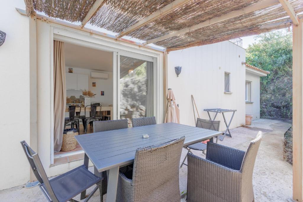 einen blauen Tisch und Stühle auf einer Terrasse in der Unterkunft L'Alivi di Losari 7 - piscine naturelle et jacuzzi in Belgodère