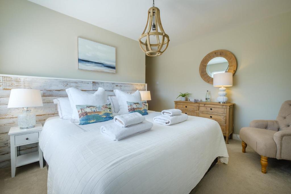 a bedroom with a white bed with two towels on it at The Bolt Hole in Silverdale