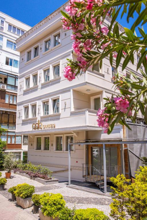 un edificio bianco con fiori rosa di fronte di Ada Suites Nisantasi a Istanbul
