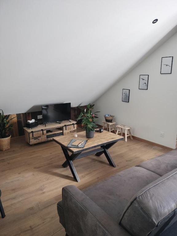 a living room with a couch and a table at Appartement neuf Le Grenier d'Oscar in La Bresse