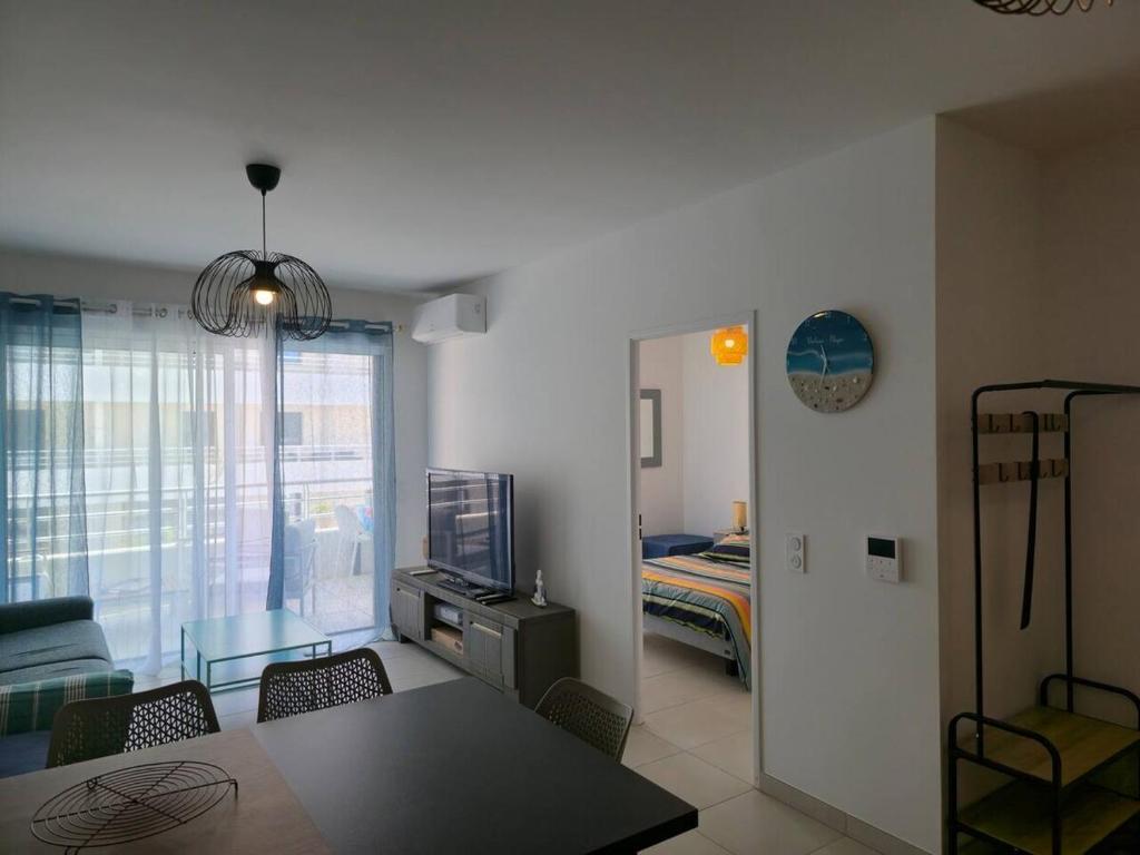 un soggiorno con una camera con un letto e un tavolo di Valras Panarea 4 people a Valras-Plage
