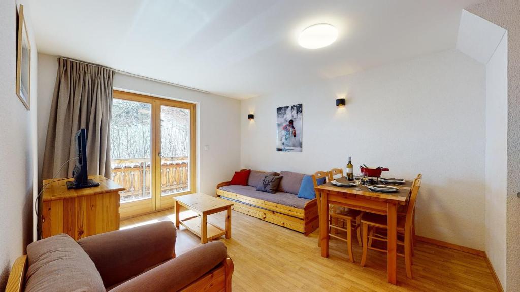 a living room with a couch and a table at Pracondu 2 307 - OUTDOOR & FUN charming apartment in Nendaz