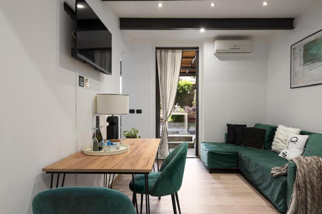 un soggiorno con un divano verde e un tavolo di Nadia's Lovely Home - WITH PRIVATE GARDEN AND JACUZZI a Firenze