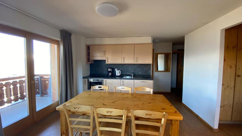 a kitchen with a wooden dining table and chairs at Pracondu 1 401 - OUTDOOR & FUN apartment 8 pers in Nendaz