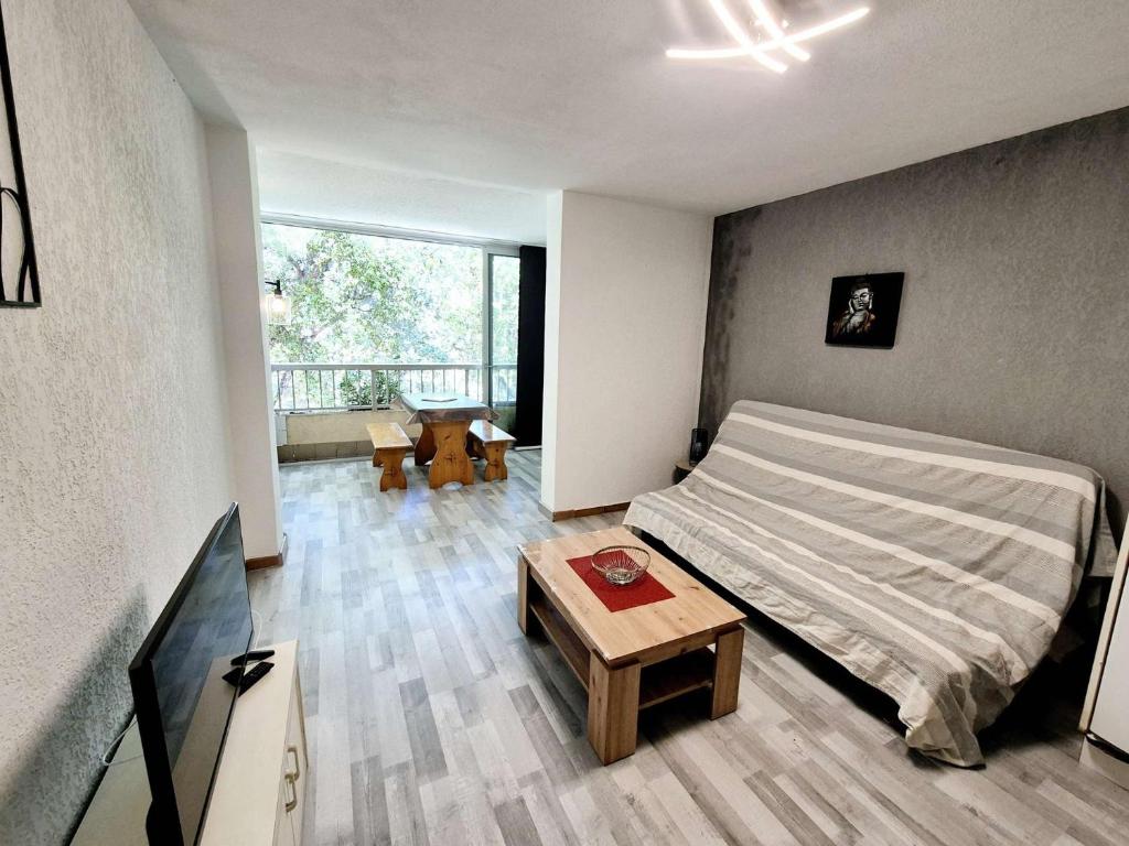 une chambre avec un lit et une table dedans dans l'établissement Charmant studio, 4 couchages, lumineux, 500 m de la plage et des commerces..., à Saint-Elme