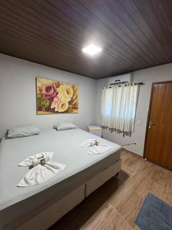 ein Schlafzimmer mit einem Bett mit Handtüchern darauf in der Unterkunft Pousada dos Passarinhos in Água Boa