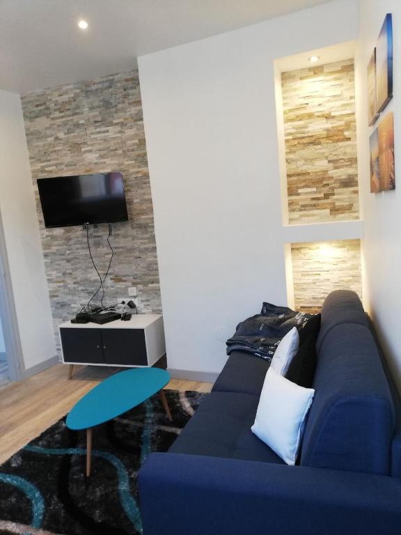 un salon avec un canapé bleu et une télévision dans l'établissement Le CosyNew 3, à Calais