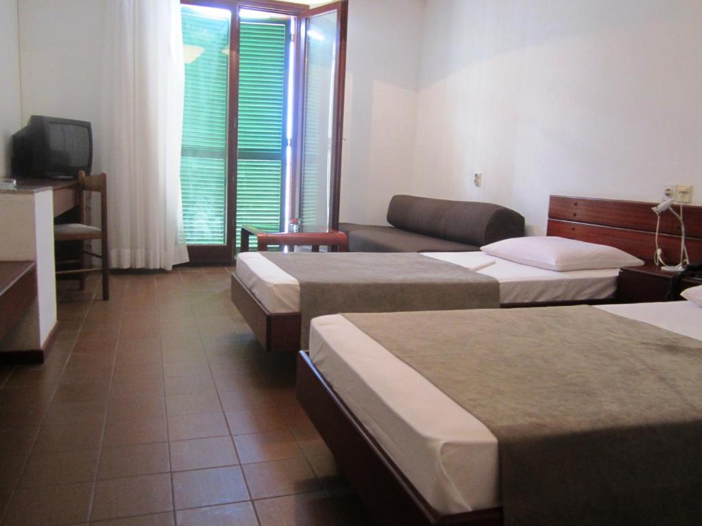 a hotel room with three beds and a couch at Hotel Zenit Neum in Neum
