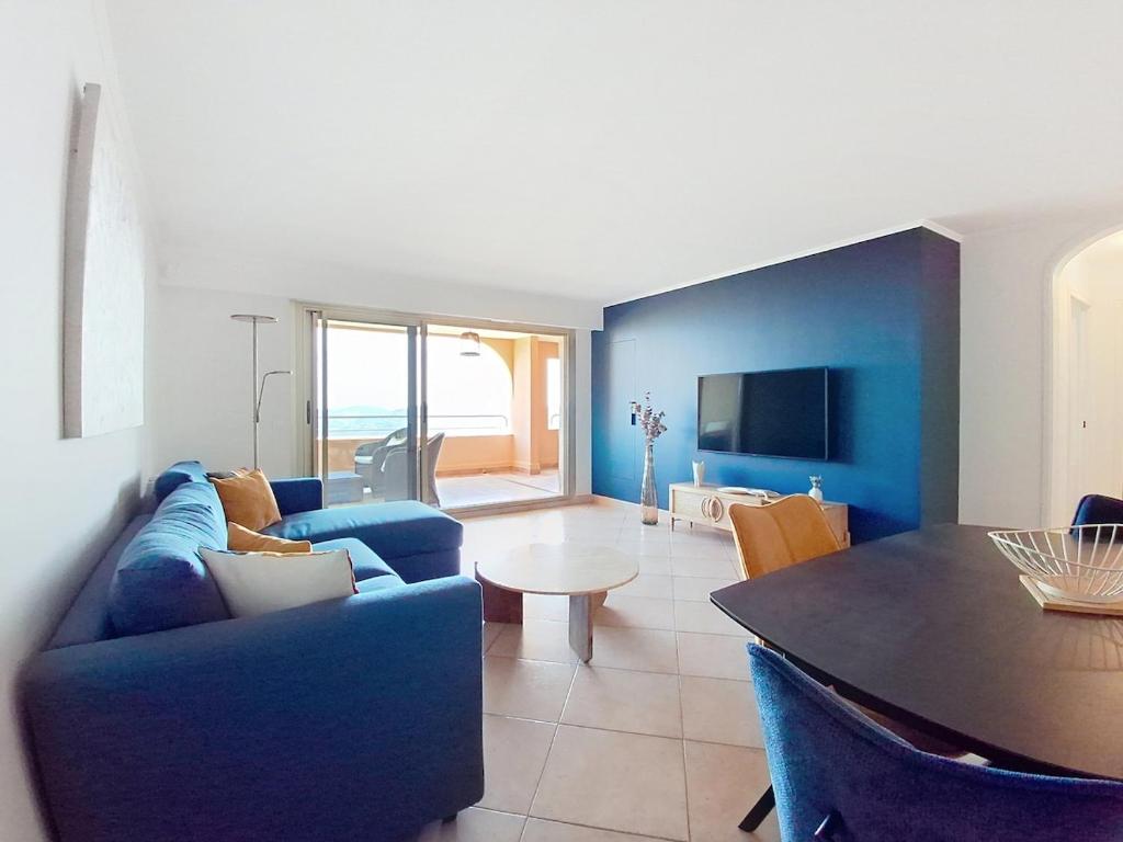 un salon avec un canapé bleu et une table dans l'établissement Superbe appartement 3P rénové dans le Domaine du Grand Duc, à Mandelieu-la-Napoule