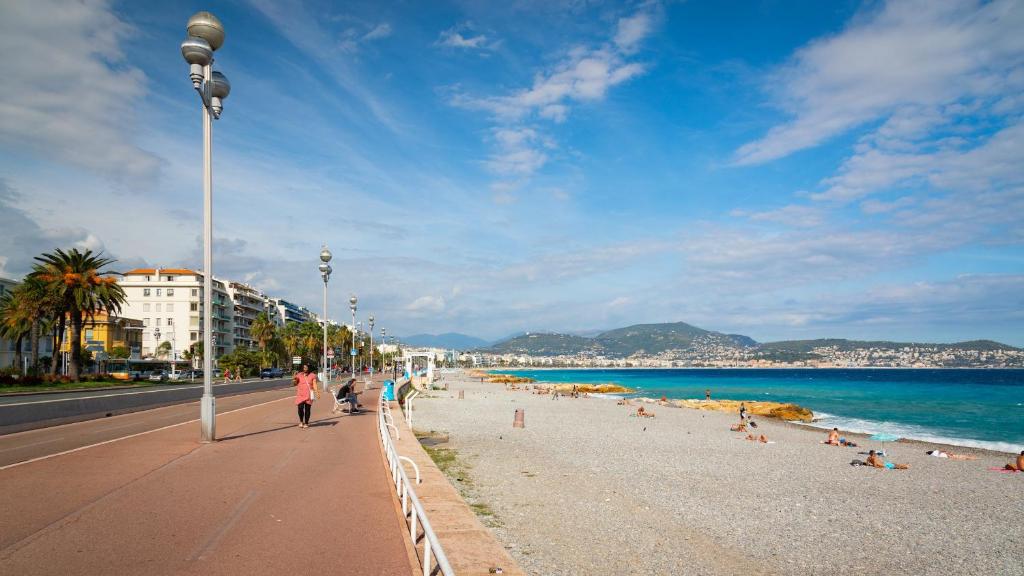 un groupe de personnes marchant sur une plage dans l'établissement Studio Calif, face tram proche Mer, à Nice