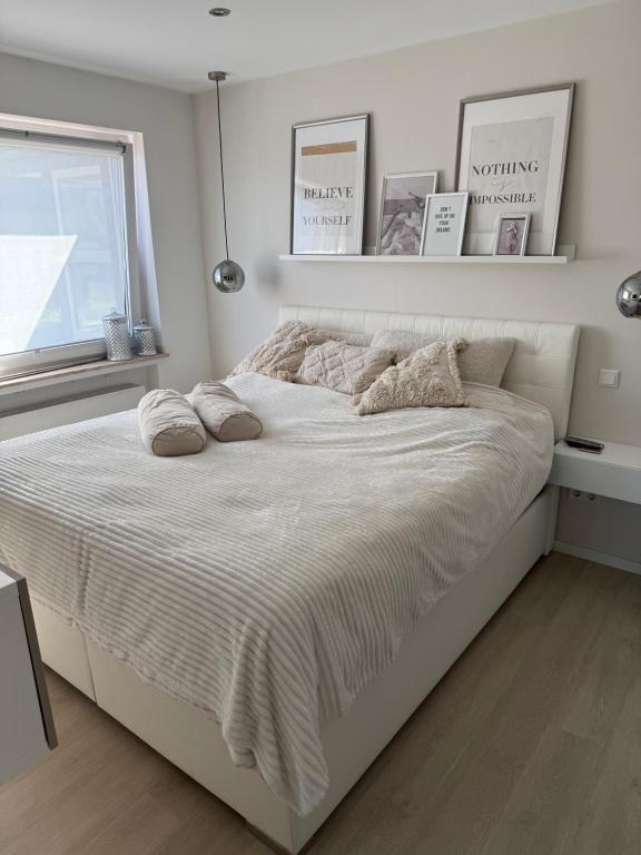 a white bed in a bedroom with a window at Zentral mit Garten für bis zu 6 Personen in Paderborn